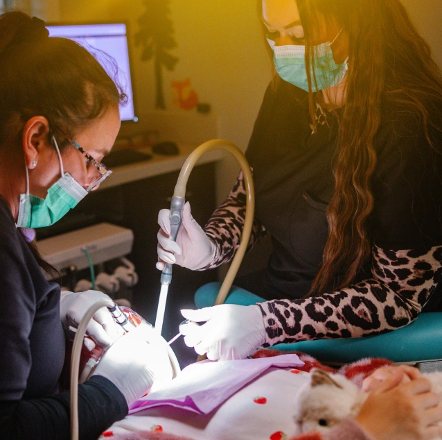 Pediatric dental team performing a tooth extraction procedure for a young patient at Smile Zone in Springfield, MO.