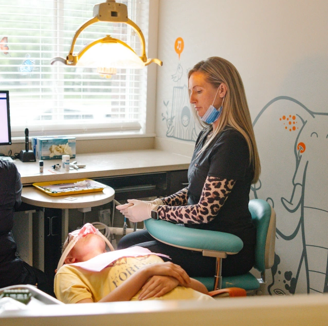 Dental professional monitoring a child receiving nitrous oxide sedation during treatment at Smile Zone in Springfield, MO.