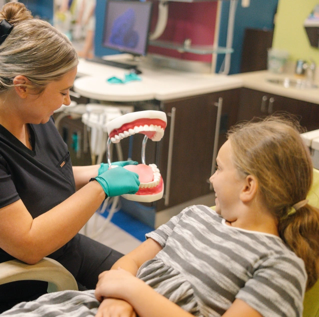 Child learning healthy brushing habits during a dental visit at Smile Zone Springfield, MO.