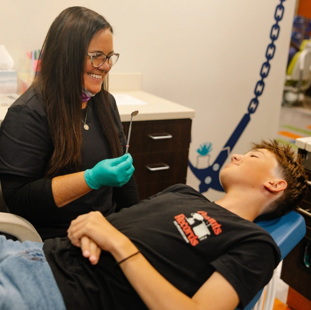 Pediatric dental professional welcoming a young patient during a routine dental visit at Smile Zone in Springfield, MO.