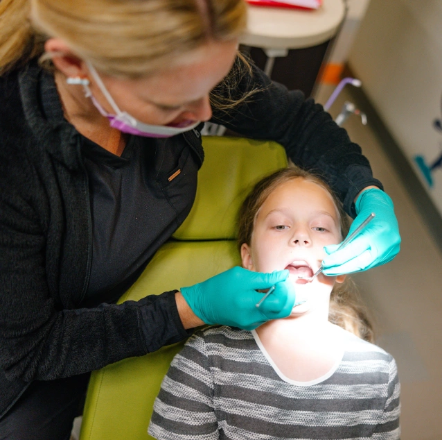 Dental professional applying protective sealants to a young patient's teeth at Smile Zone in Springfield, MO.