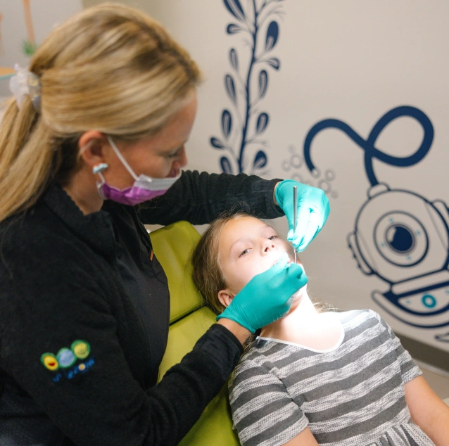 Pediatric dentist applying Silver Diamine Fluoride (SDF) treatment to a child's tooth at Smile Zone in Springfield, MO.