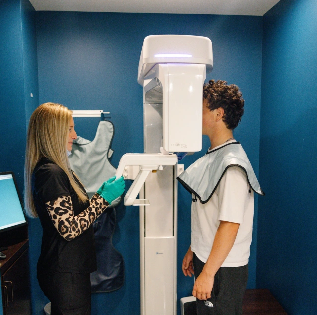 Dental team member assisting a young patient with digital dental x-rays at Smile Zone in Springfield, MO.